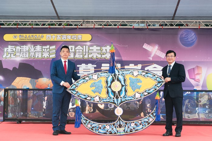 Michael Chai (left), Vice President of the Malaysian Chamber of Commerce and Industry in Taipei (MCCI), presents a 'moon kite' as a congratulatory gift to Chang Hsin-liang, President of National Formosa University (NFU).